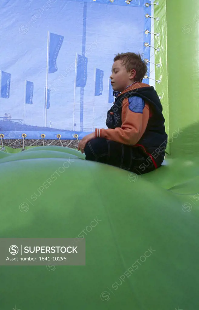 Side profile of boy meditating in bouncy castle, Hamburg, Germany