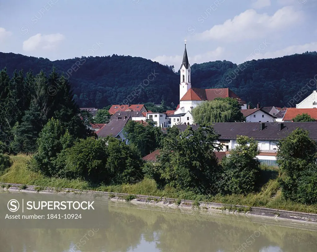 Church in a town at river side, Marktl, Bavaria, Germany