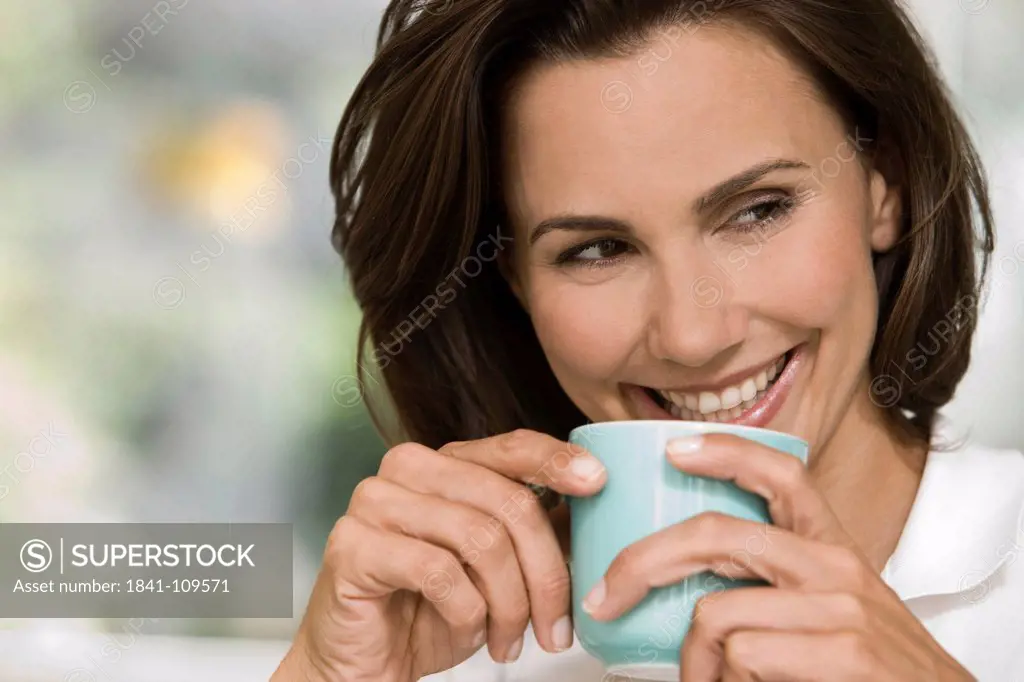 Smiling woman holding cup of coffee