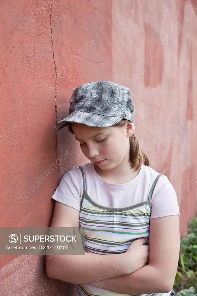 Serious girl leaning at wall