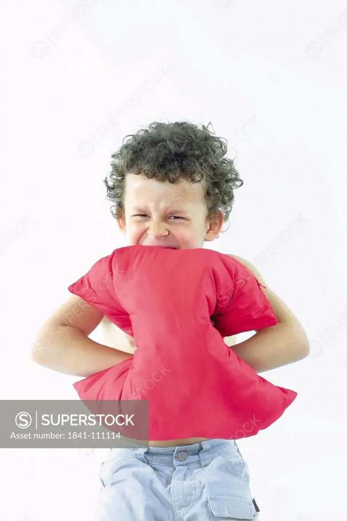 Portrait of boy pressing pillow