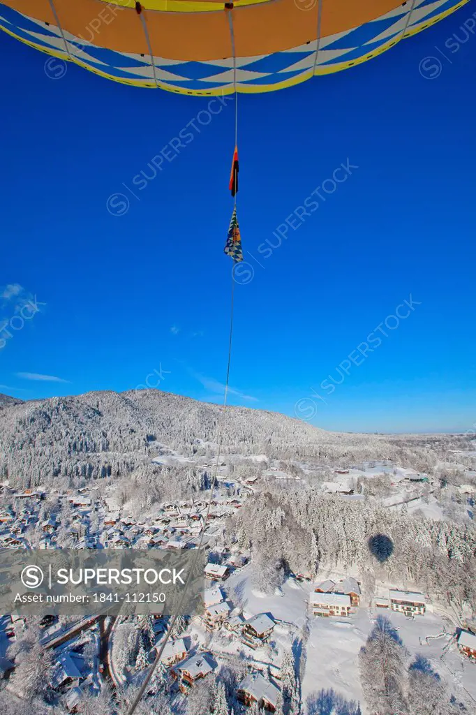 Hot_air balloon above winter landscape in Tegernsee Valley, Bavaria, Germany, aerial shot