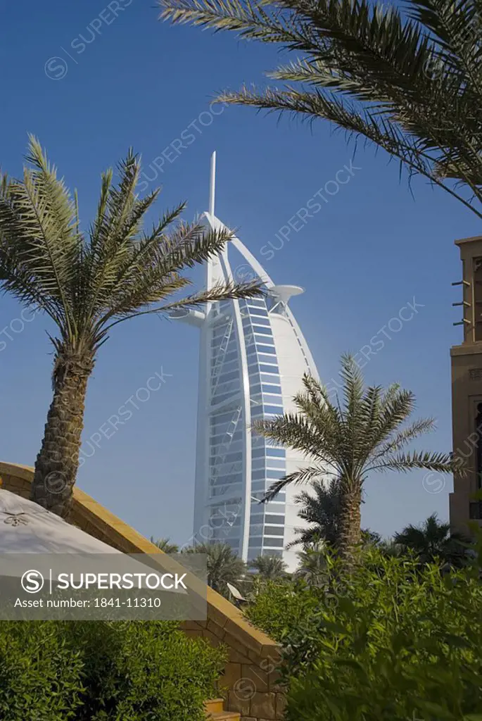 Trees with hotel in background, Burj Al Arab Hotel, Dubai, United Arab Emirates