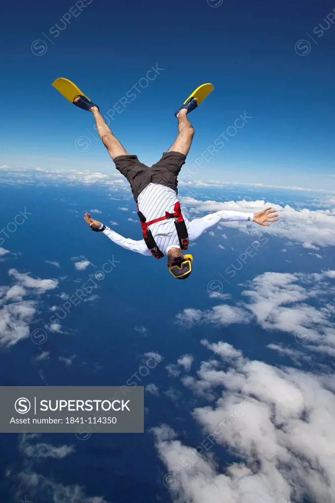 Skydiver with flippers and diving goggles in the air