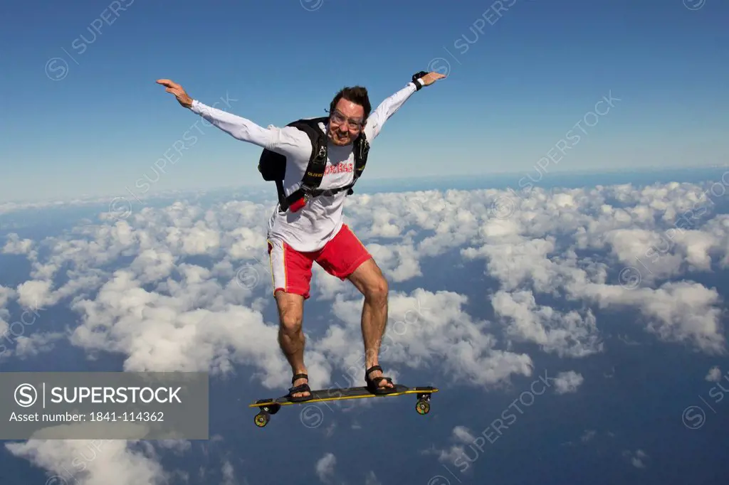 Skydiver with skateboard in the air
