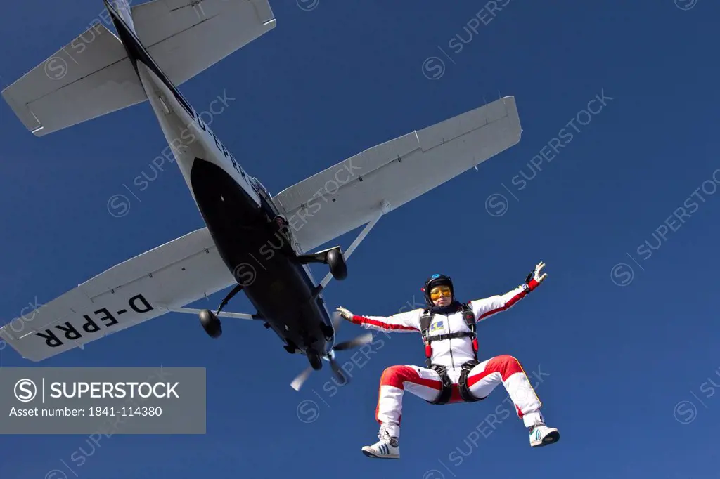 Female skydiver jumping off airplane