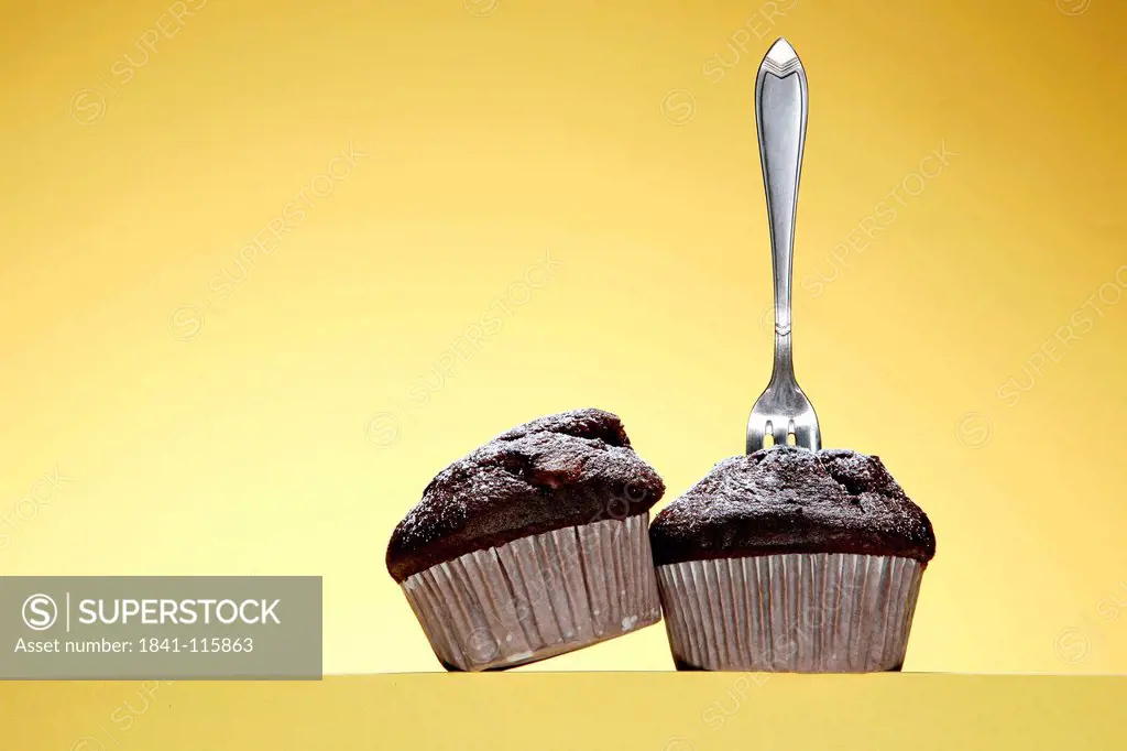 Two chocolate muffins with pastry fork