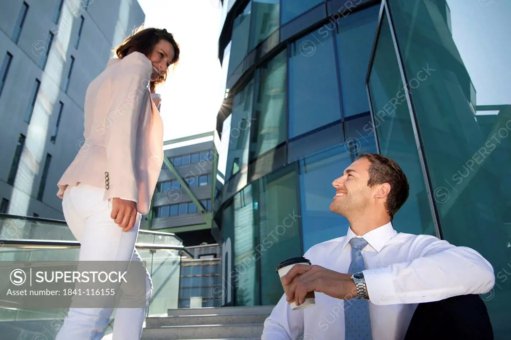 Smiling businessman and businesswoman on stairs