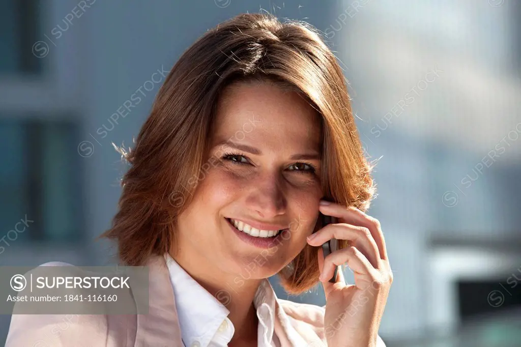 Smiling businesswoman on cell phone, portrait