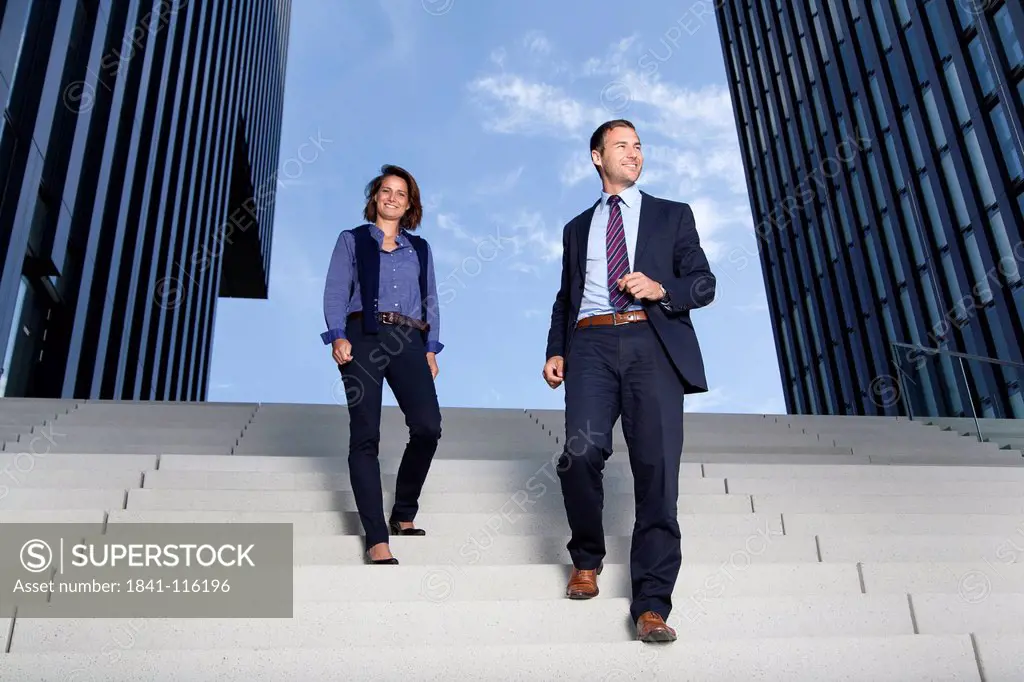 Businessman and businesswoman walking on stairs