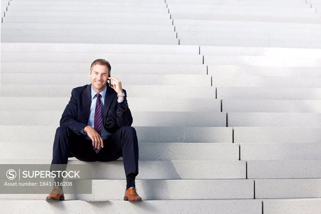 Businessman on the phone on stairs