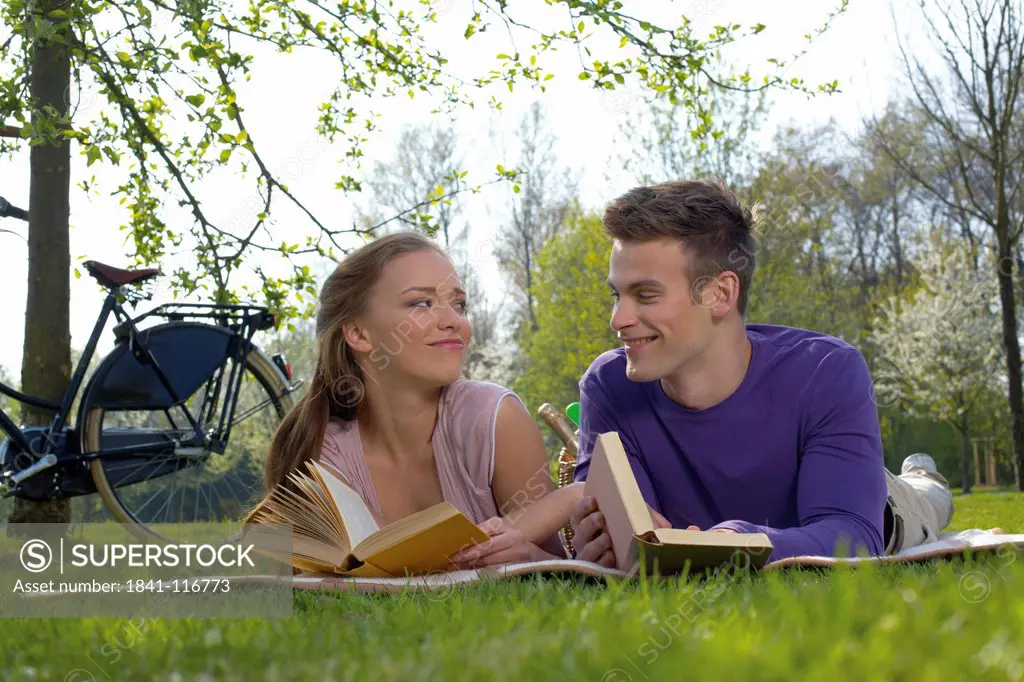 Young couple reading on a meadow