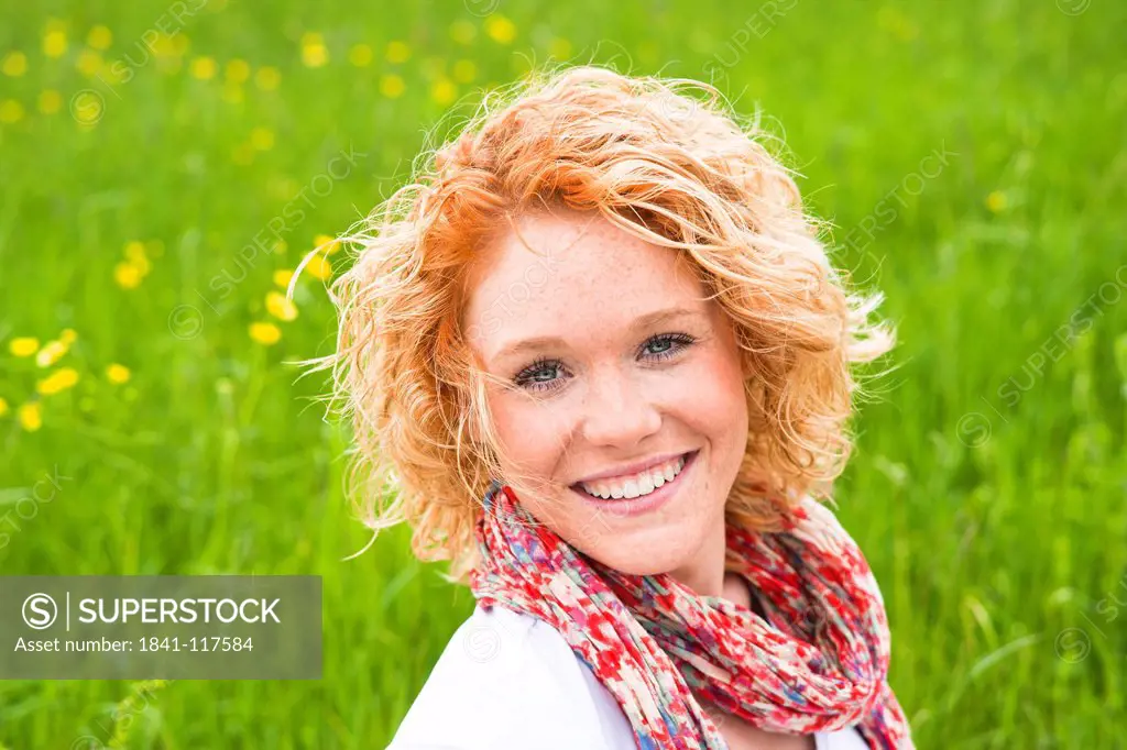 Smiling young woman in meadow