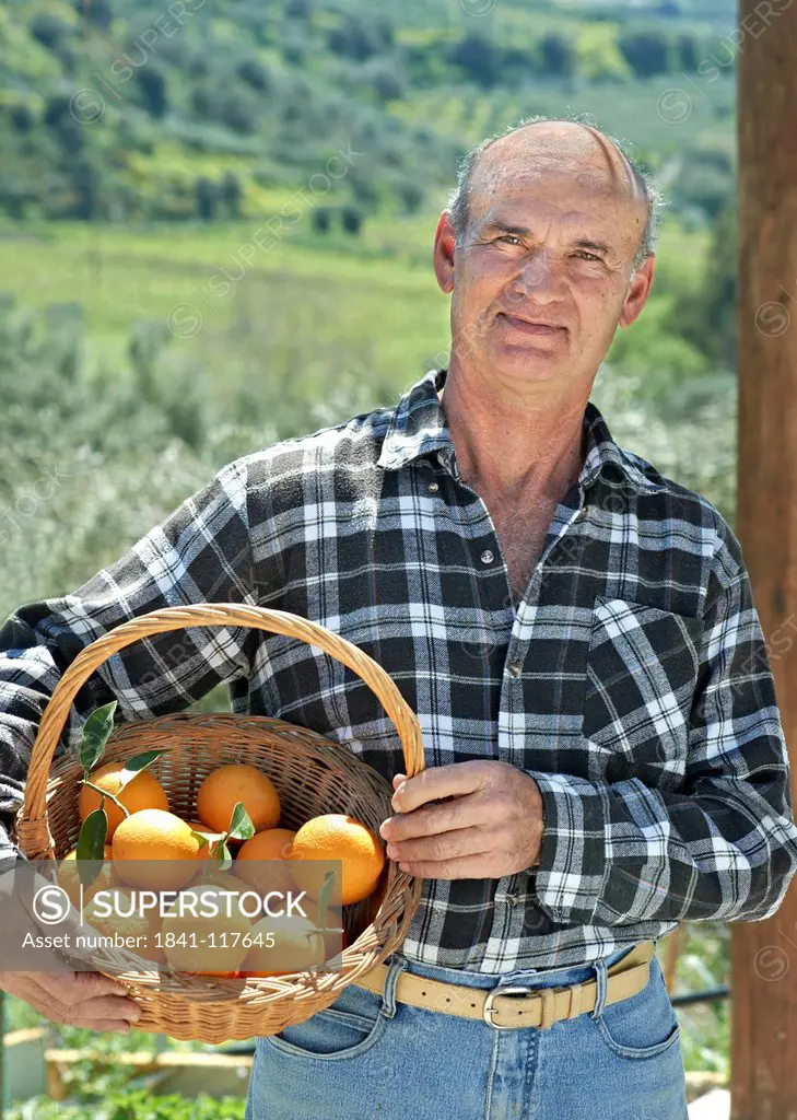 Senior man with a basket of oranges, Iraklion, Crete, Greece, Europe