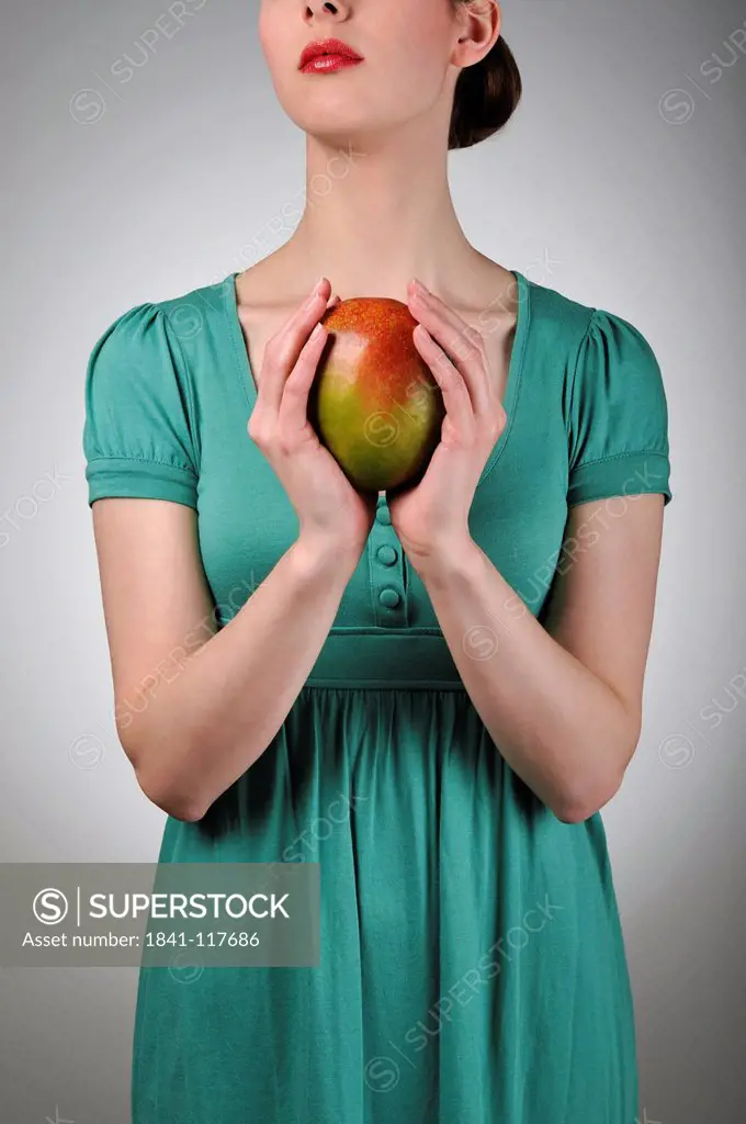 Young woman holding a mango
