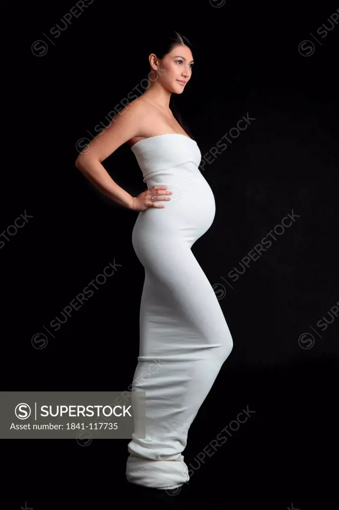 Pregnant woman standing in elegant dress