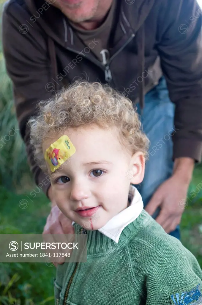 Father and son with plaster on forehead