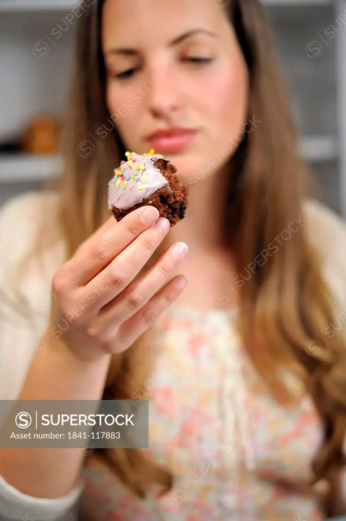 Young woman holding muffin