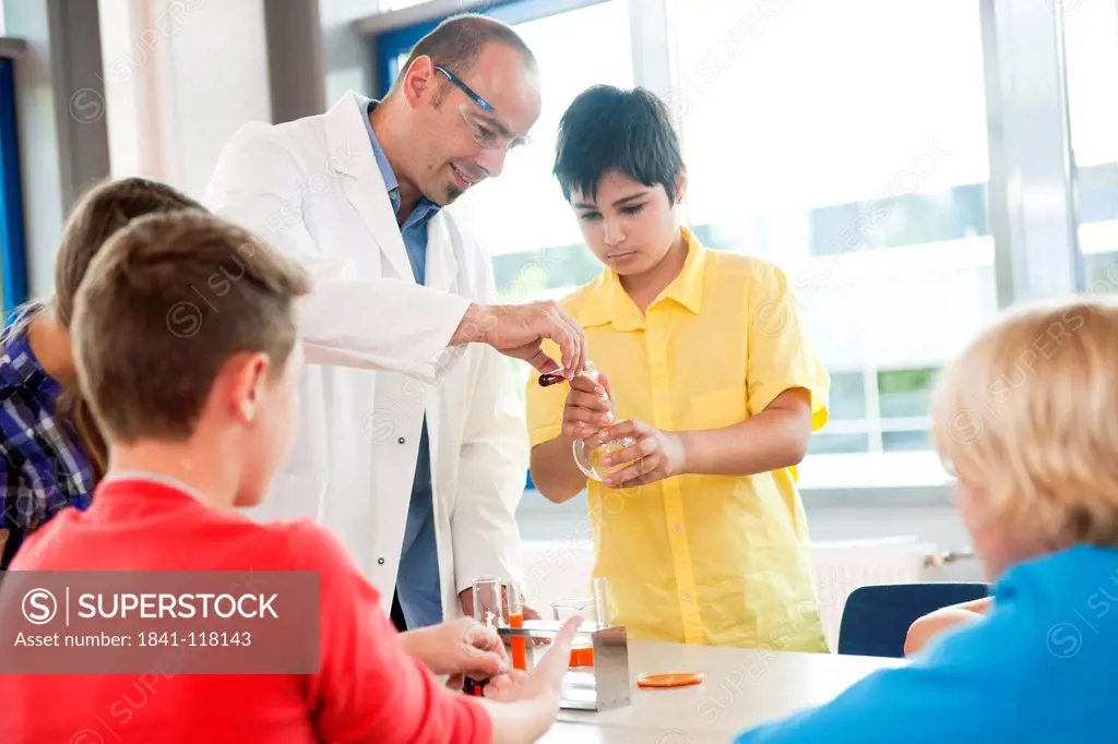 Teacher and pupils experimenting in chemical class
