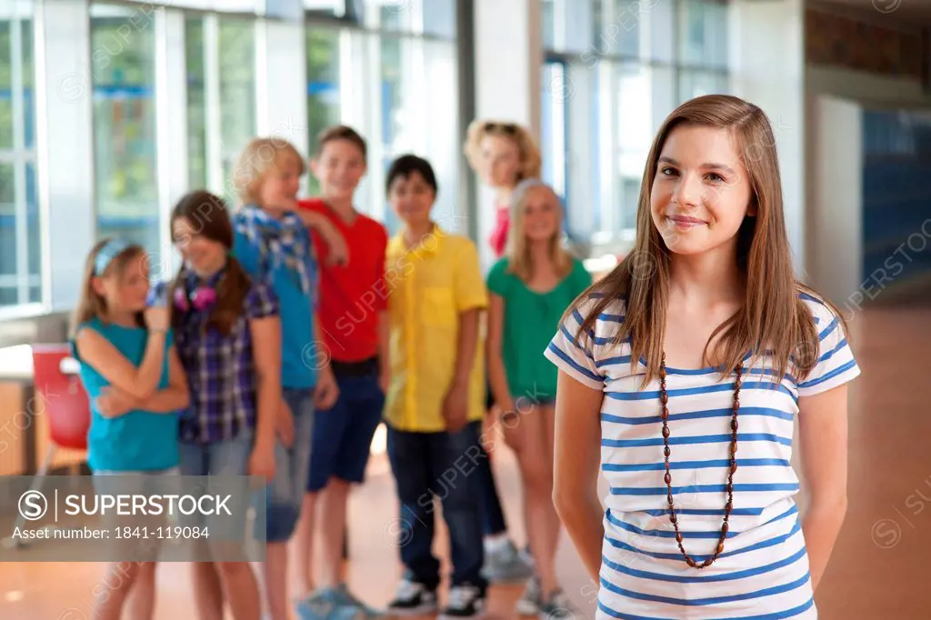 Smiling teenage girl in front of group of schoolchildren