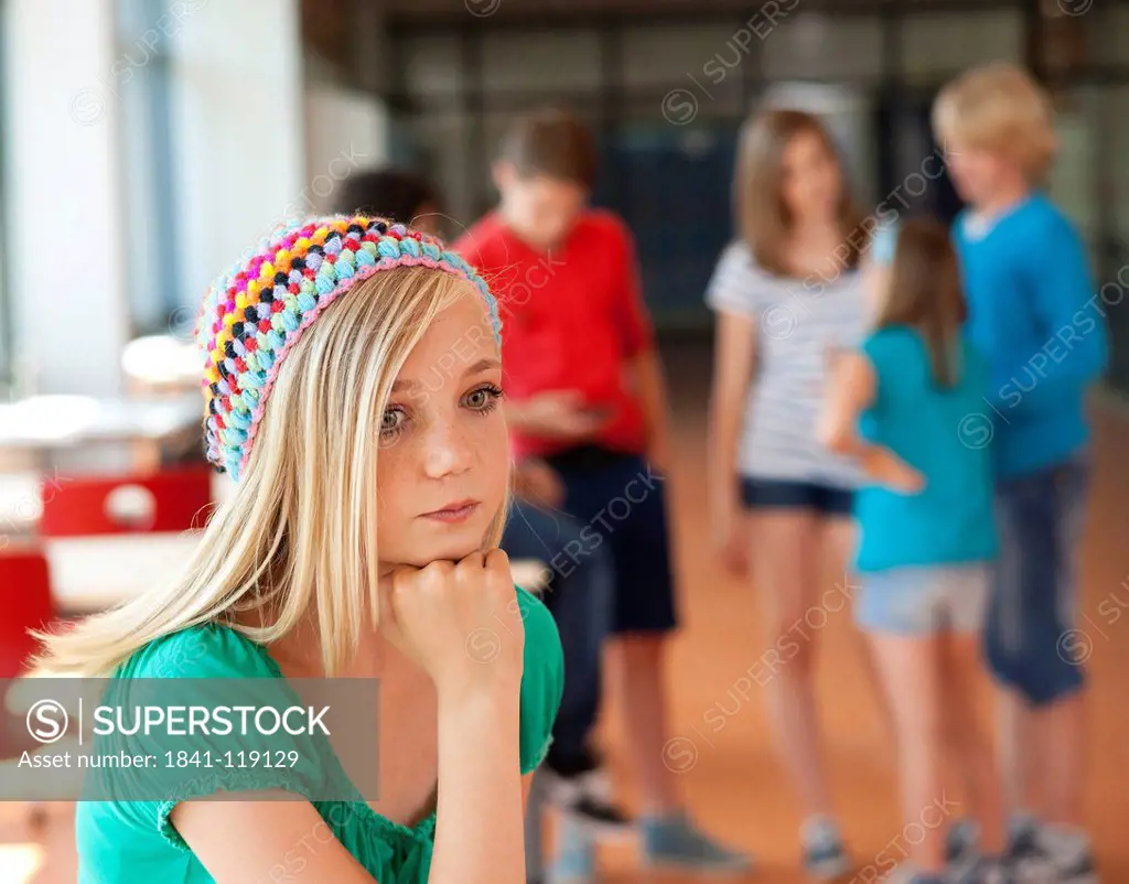 Serious teenage girl in front of group of schoolchildren