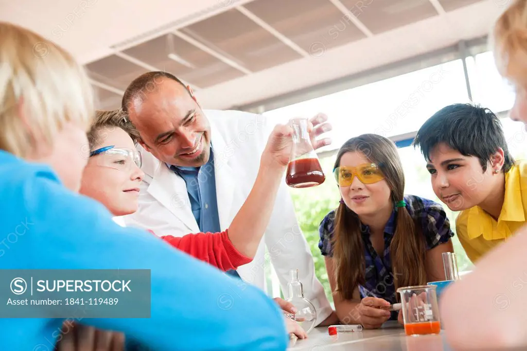 Teacher and pupils experimenting in chemical class