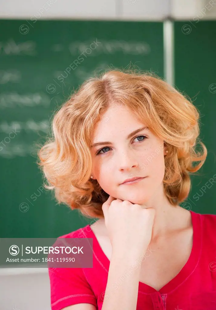 Thoughtful teenage girl in classroom, portrait