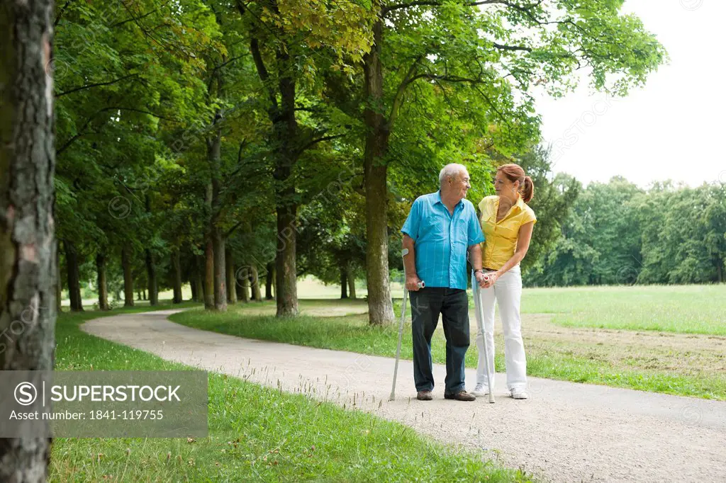 Woman walking with old man in park