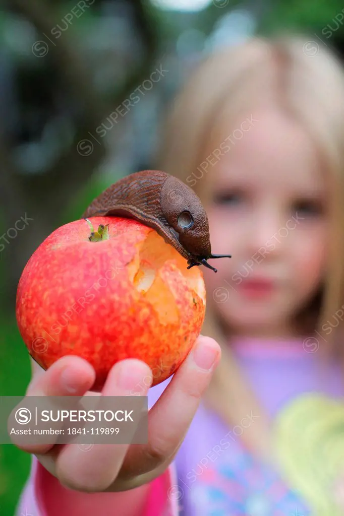 Girl holding an apple with a slug