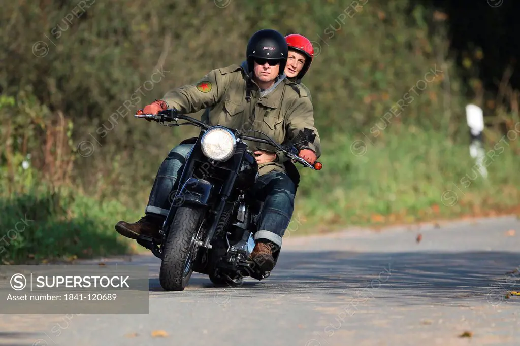 Couple riding motorbike on a country road