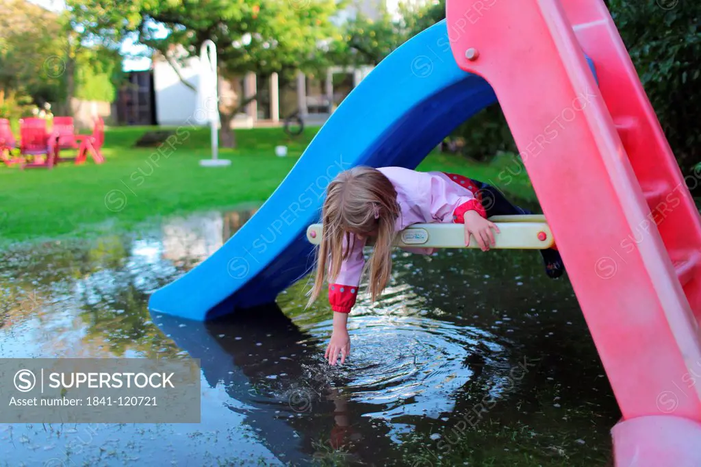 Girl lying in slide in a submerged garden