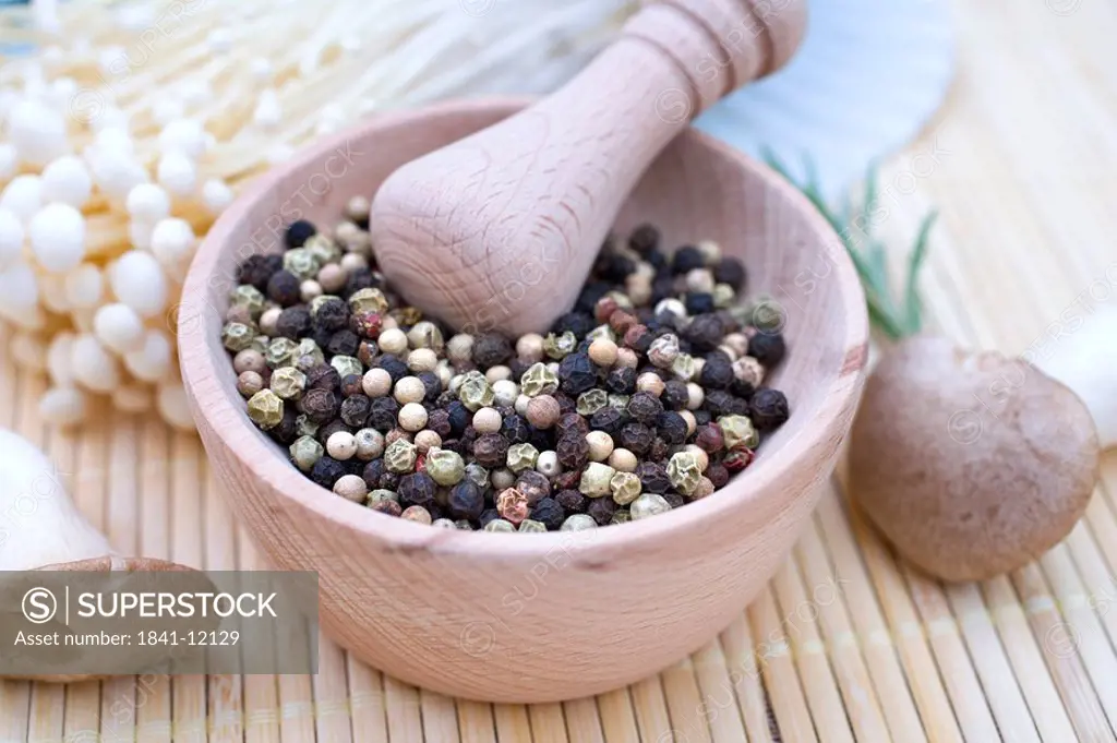 Close_up of peppercorns in mortar with pestle