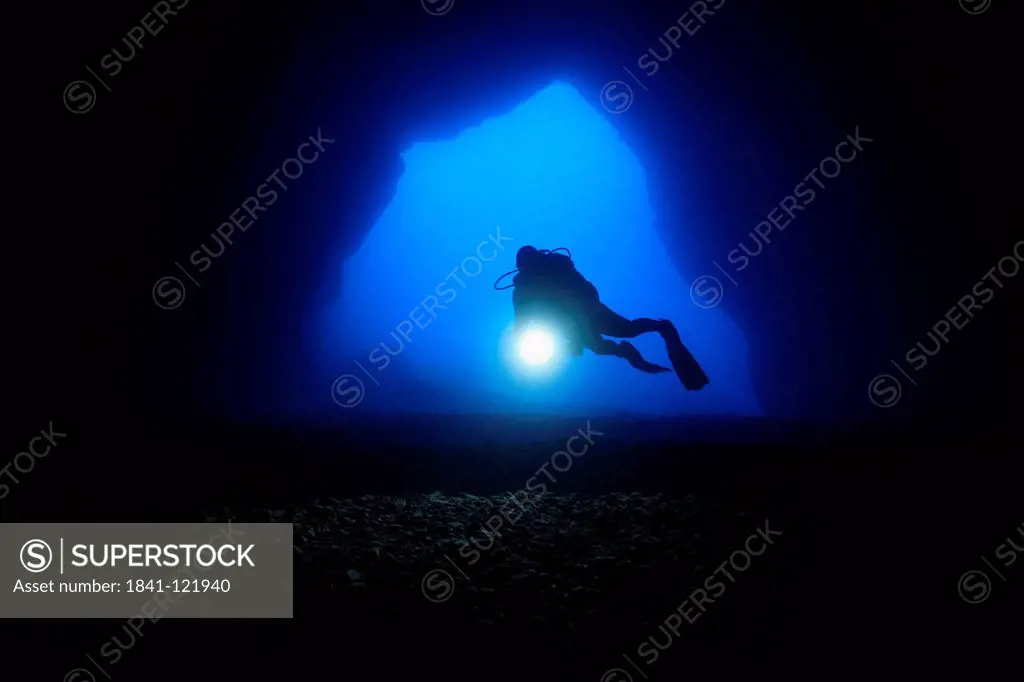 Diver in the entry of a cave, Mediterranean Sea near Gozo, Malta, underwater shot