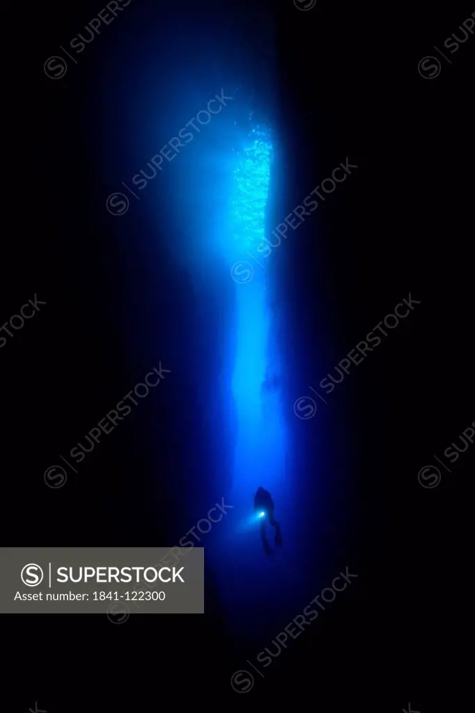 Diver in the entry of a canyon, Mediterranean Sea near Gozo, Malta, underwater shot