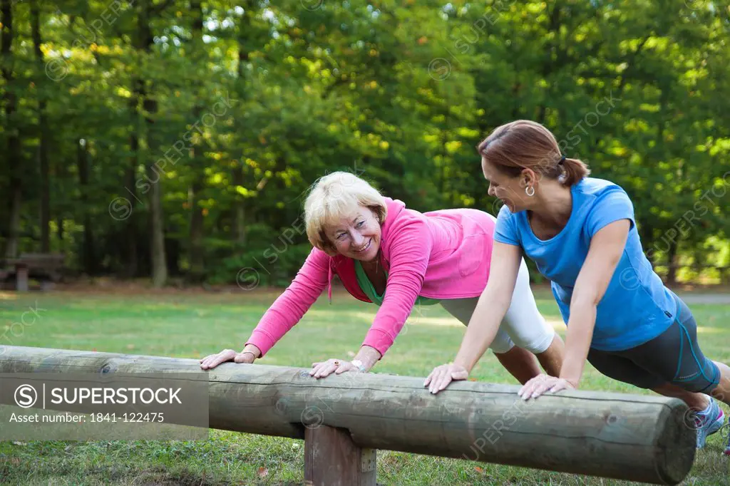 Two women doing gymnastics outdoors
