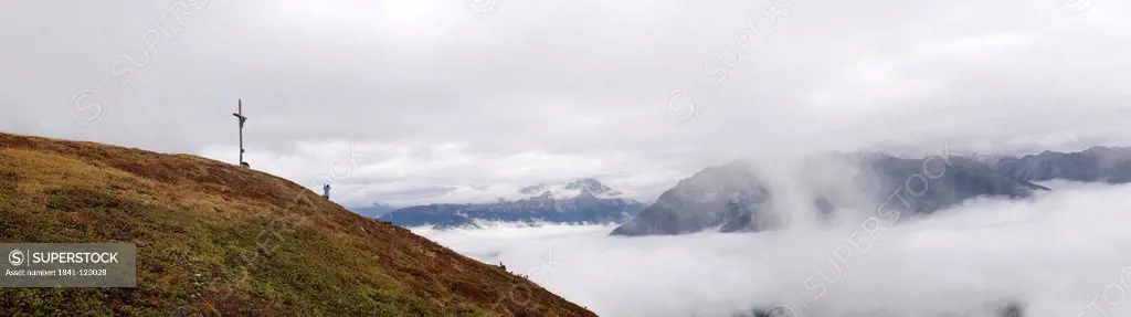 Mountainscape with summit cross in fog, South Tyrol, Italy