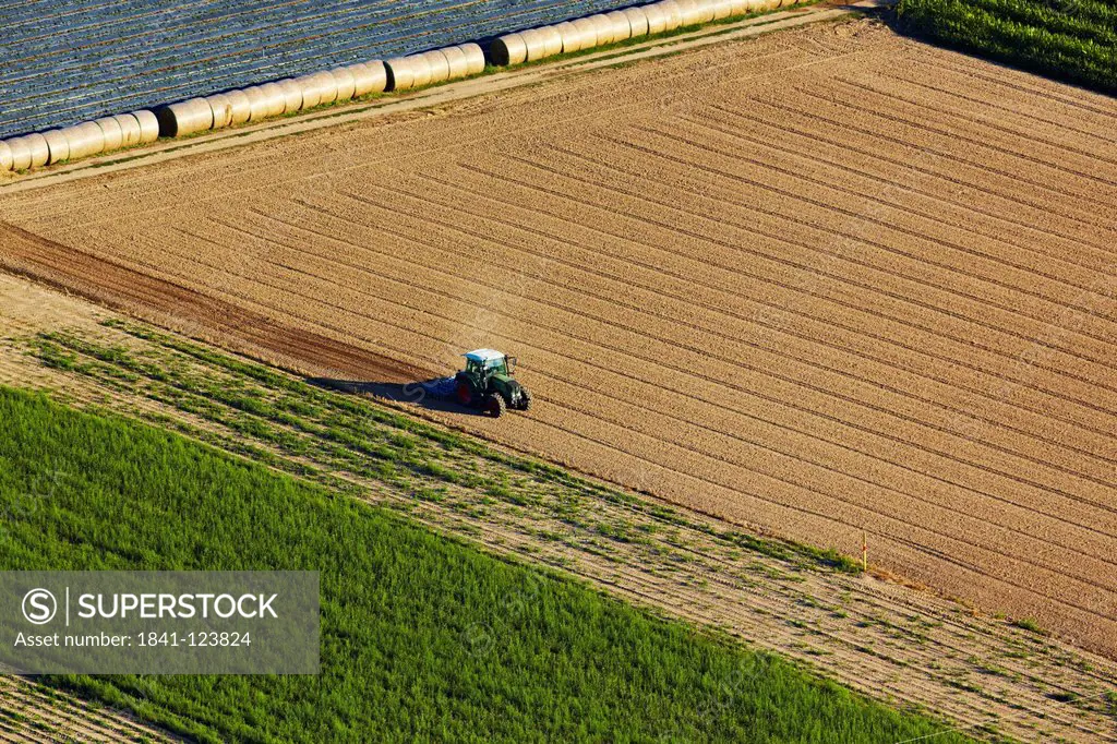 Tractor on plowed field, aerial photo