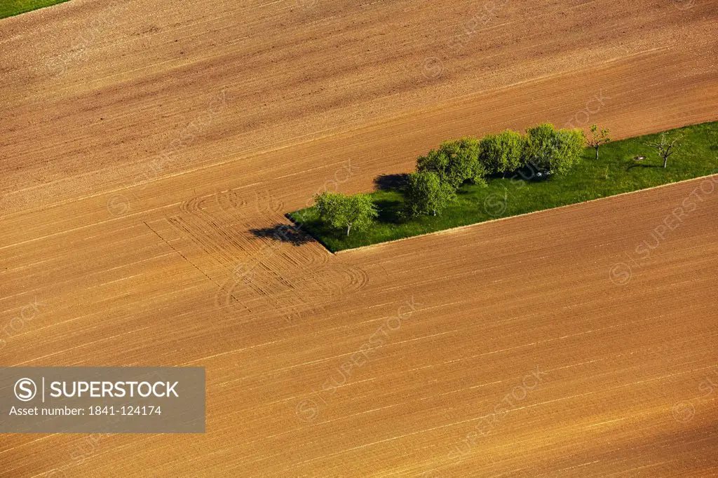 Plowed field with green area, aerial photo