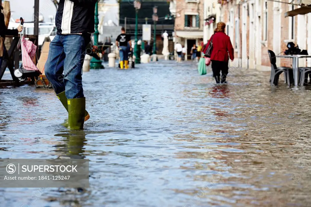 Pedestrians in high tide in Venice, Italy
