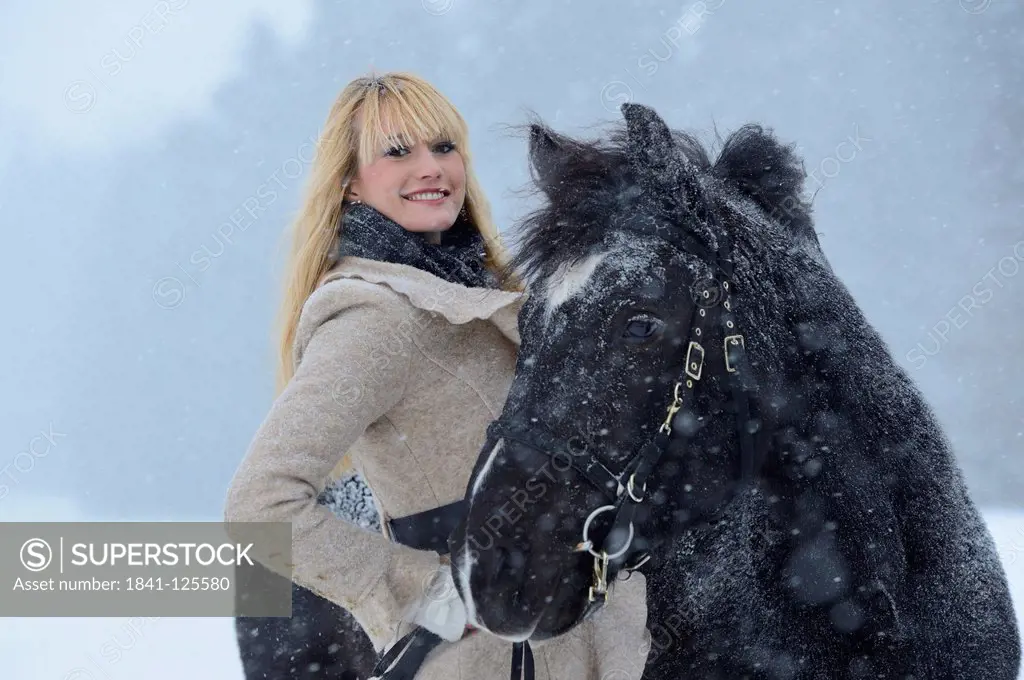 Young woman with horse in snow, Upper Palatinate, Germany, Europe