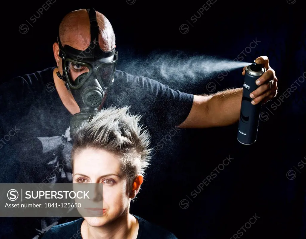 Hairdrresser applying hairspray to woman´s head