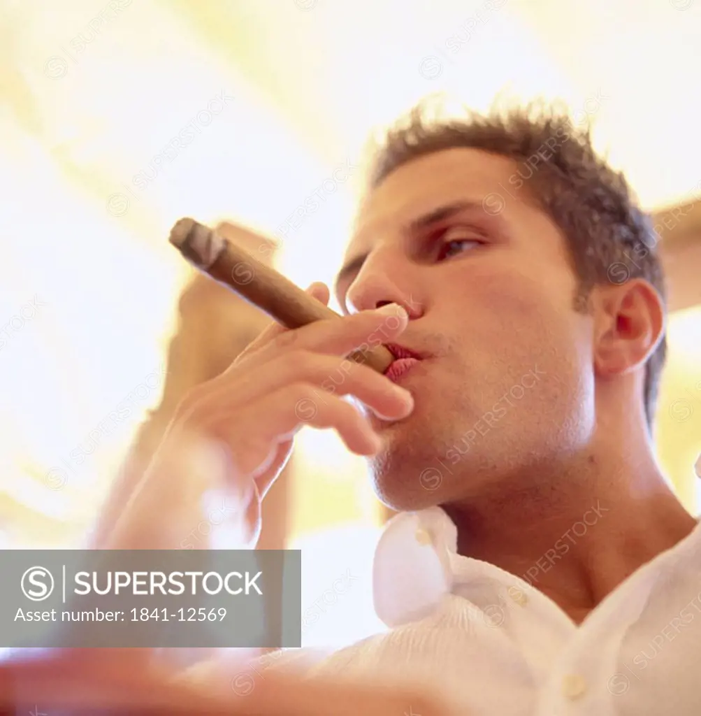 Close_up of a young man smoking cigar