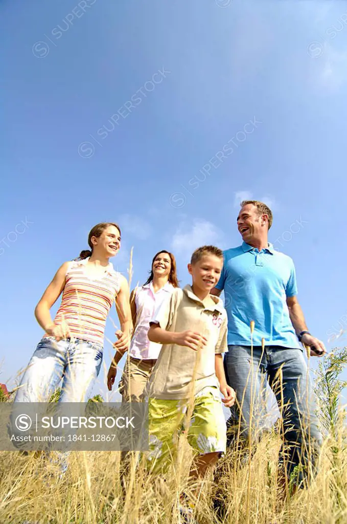 Low angle view of family walking in field
