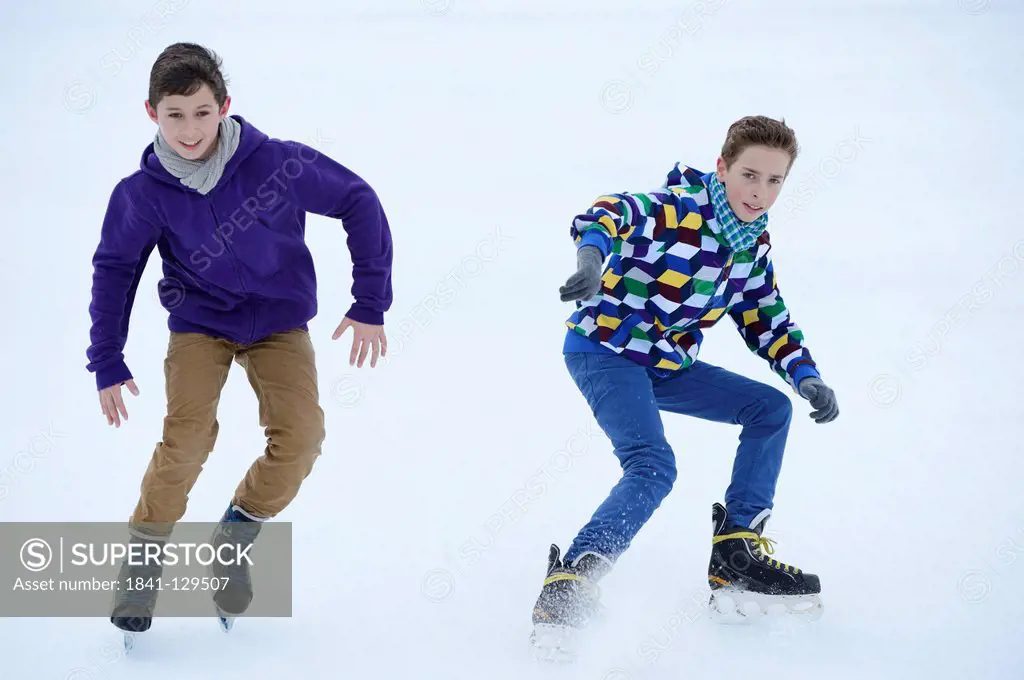 Two boys ice-skating on a frozen lake