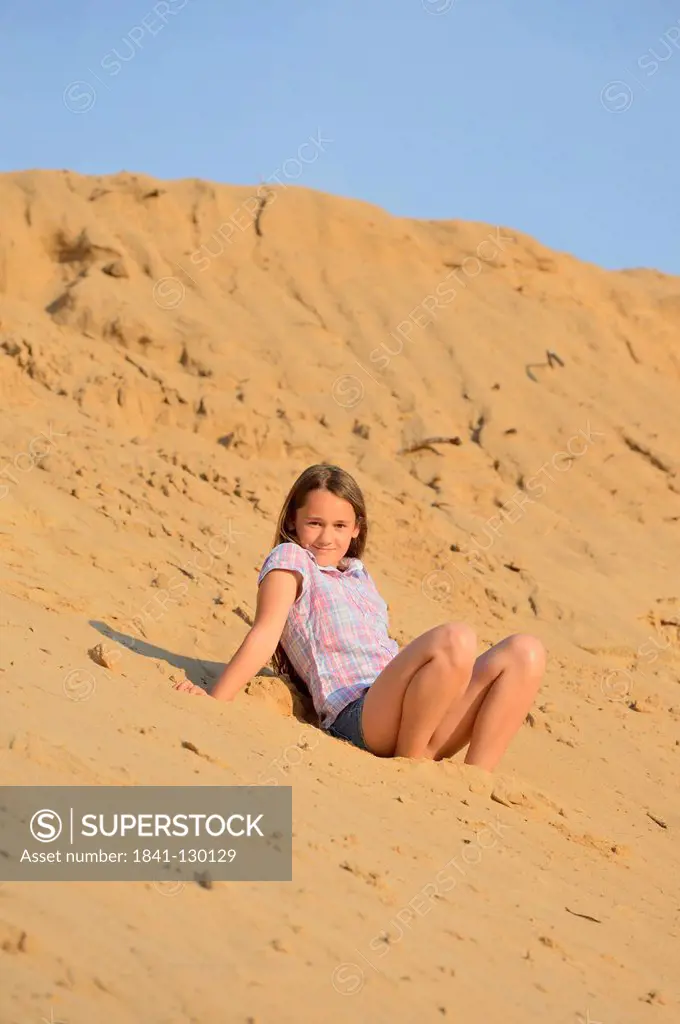 Girl sitting on a sandy beach