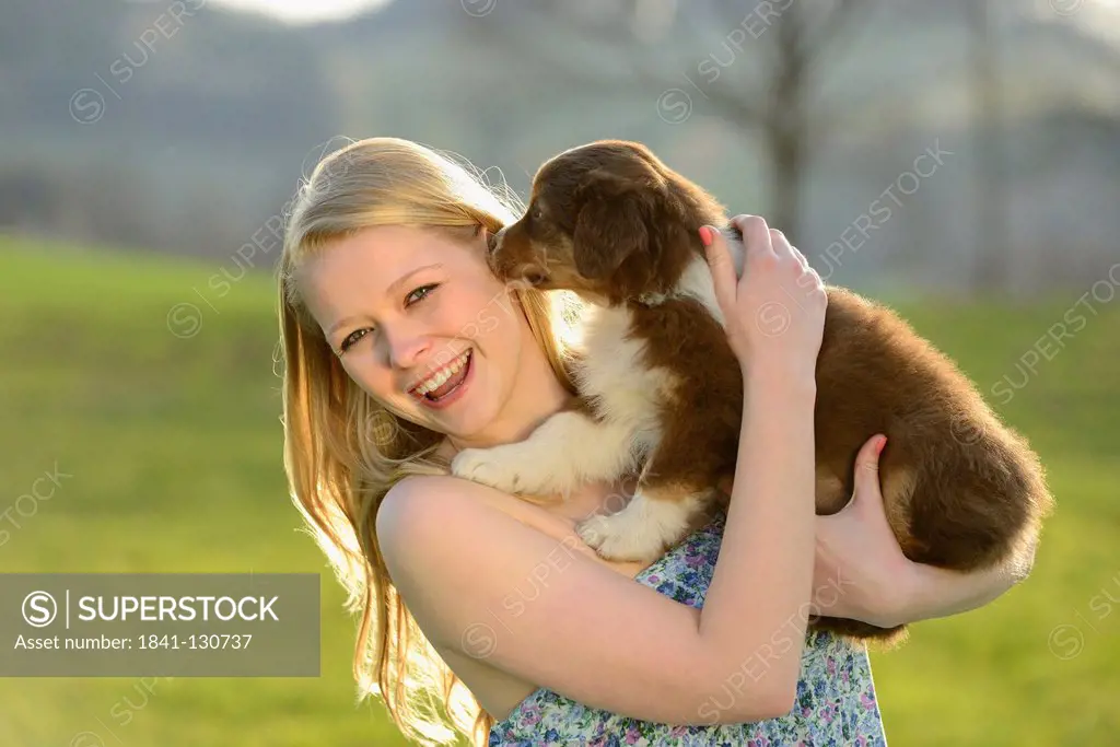 Headline: Young woman with australian sheperd puppy, Bavaria, Germany, Europe
