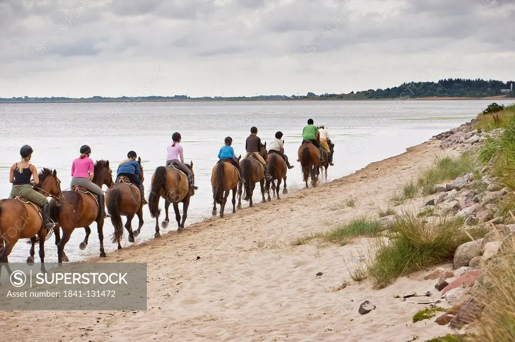 Headline: Group of riders galloping on beach of Sylt, Schleswig-Holstein, Germany