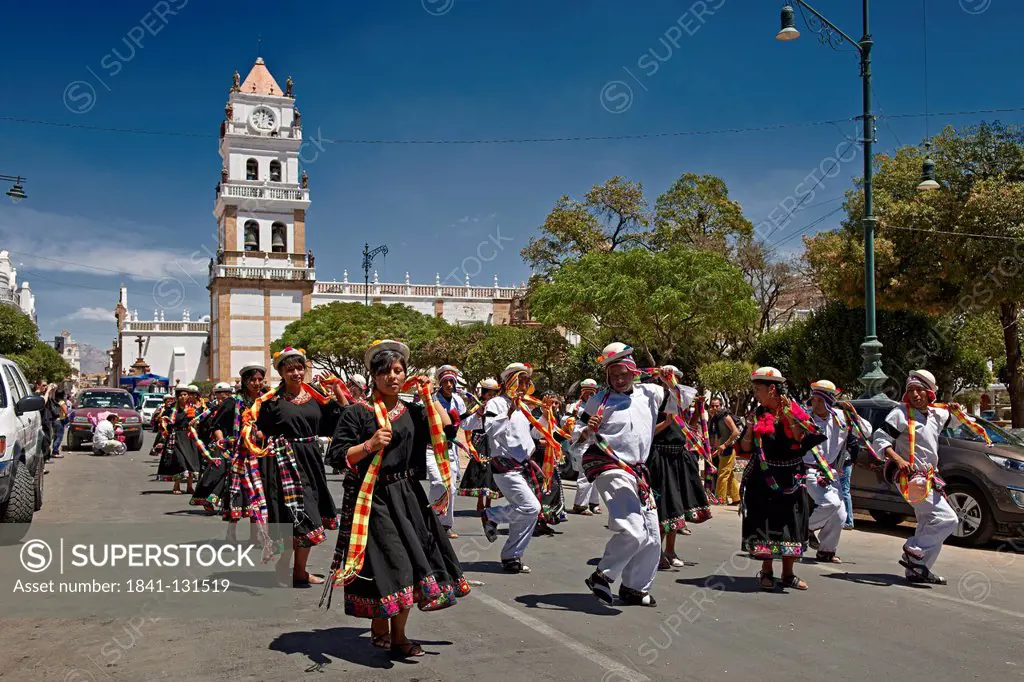 Headline: Locals in traditional clothing dancing in Sucre, Bolivia