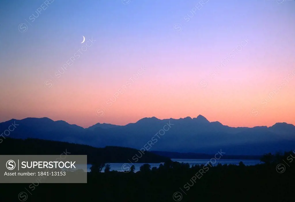 Crescent moon above a mountain range