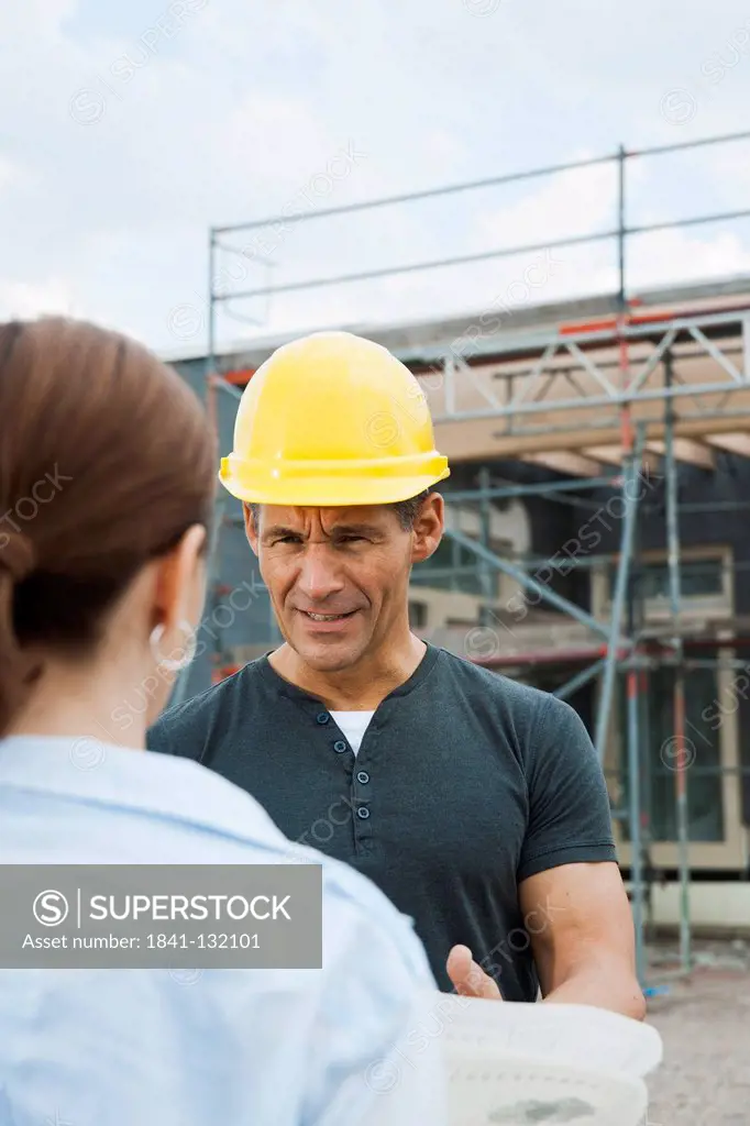 Headline: Foreman and client talking on construction site